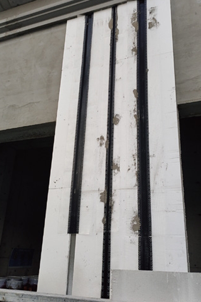 Vertical PVC divider strips mounted on plaster wall during construction